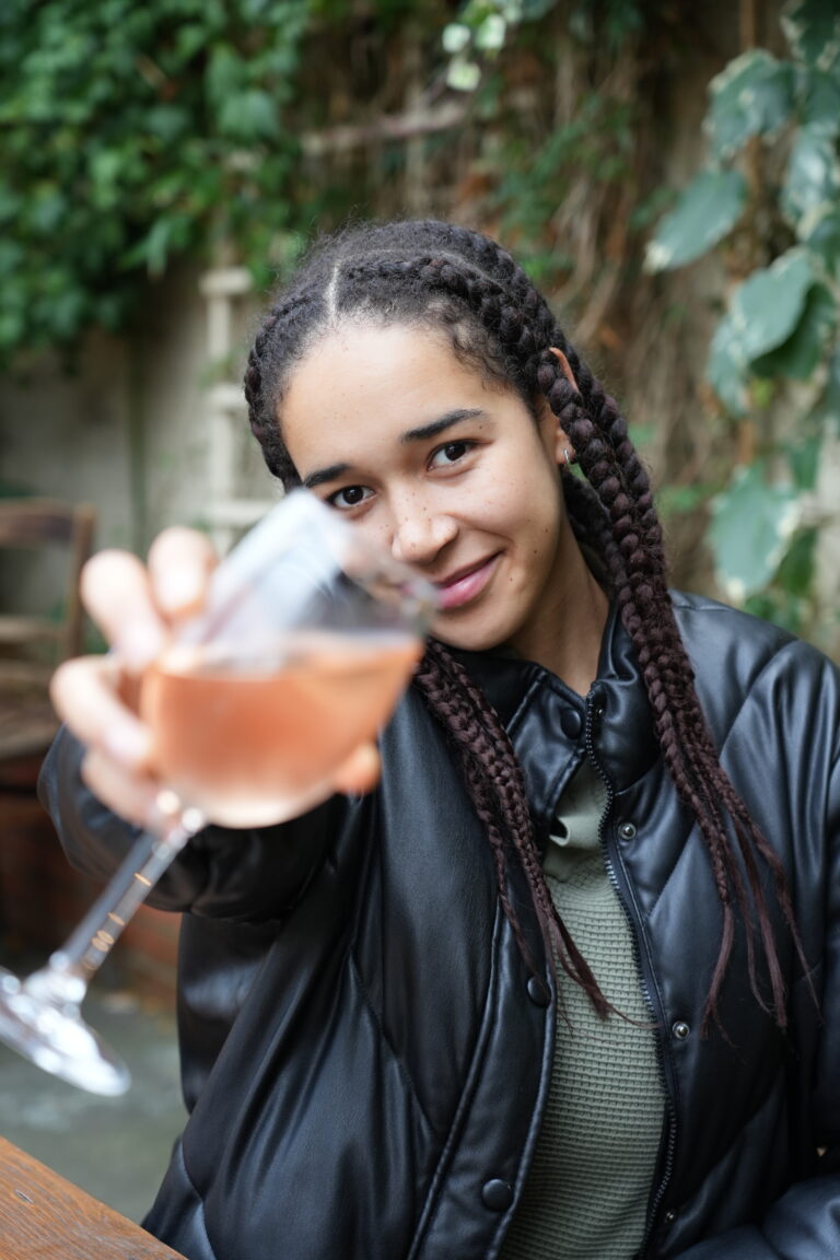 A guest raising a glass of rosé in the beer garden