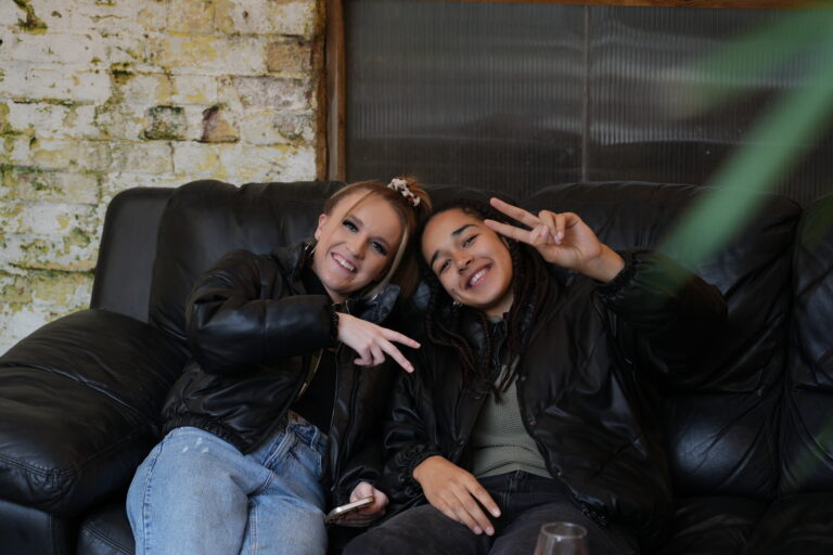 Two friends on a leather sofa at The Stag’s Head