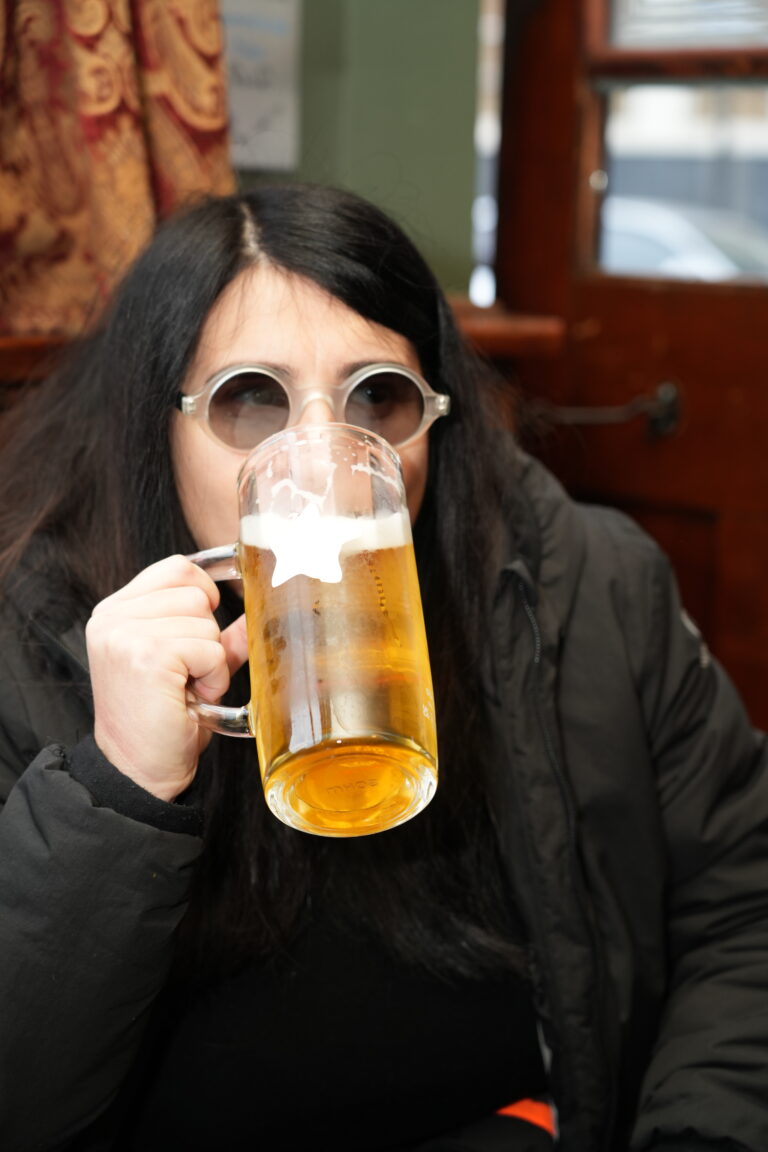 A guest drinking a pint of lager