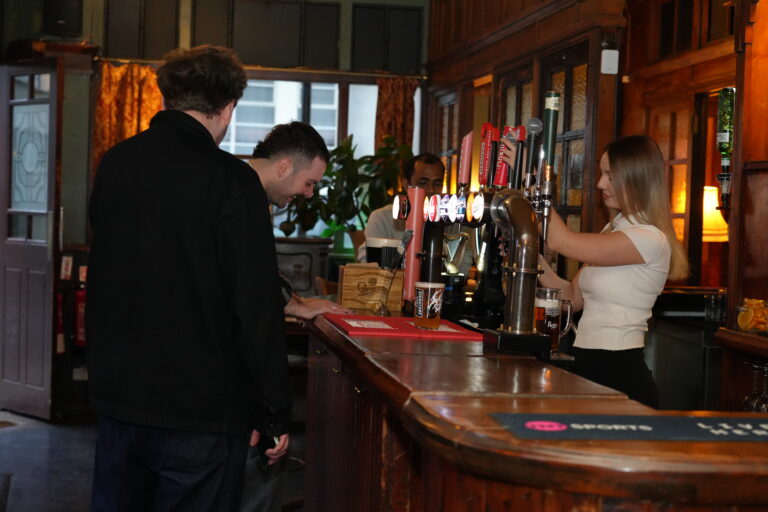 Bar staff serving customers at the bar