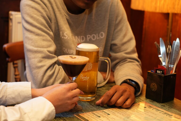 An espresso martini and a pint on a table